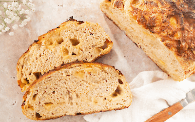 Artisan cheese bread with Jersey cheese, sliced, showing an airy crumb and golden brown crust on a light surface.
